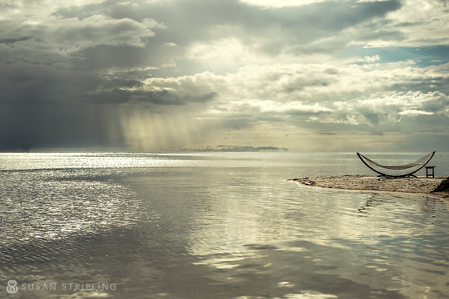 Doree and Tony's wedding on Little Palm Island, with a hammock on the beach under a cloudy sky.