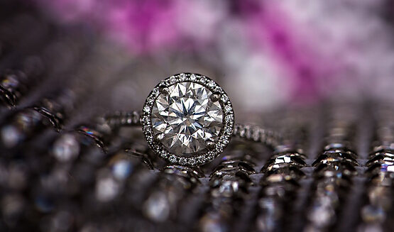An engagement ring sits on top of a wedding fabric in New York City.