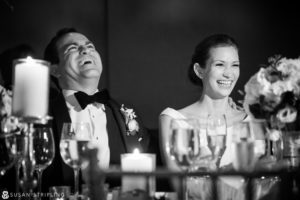 A joyful bride and groom sharing laughter at their wedding reception in New York City.