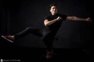 A man posing on a stool in New York City.