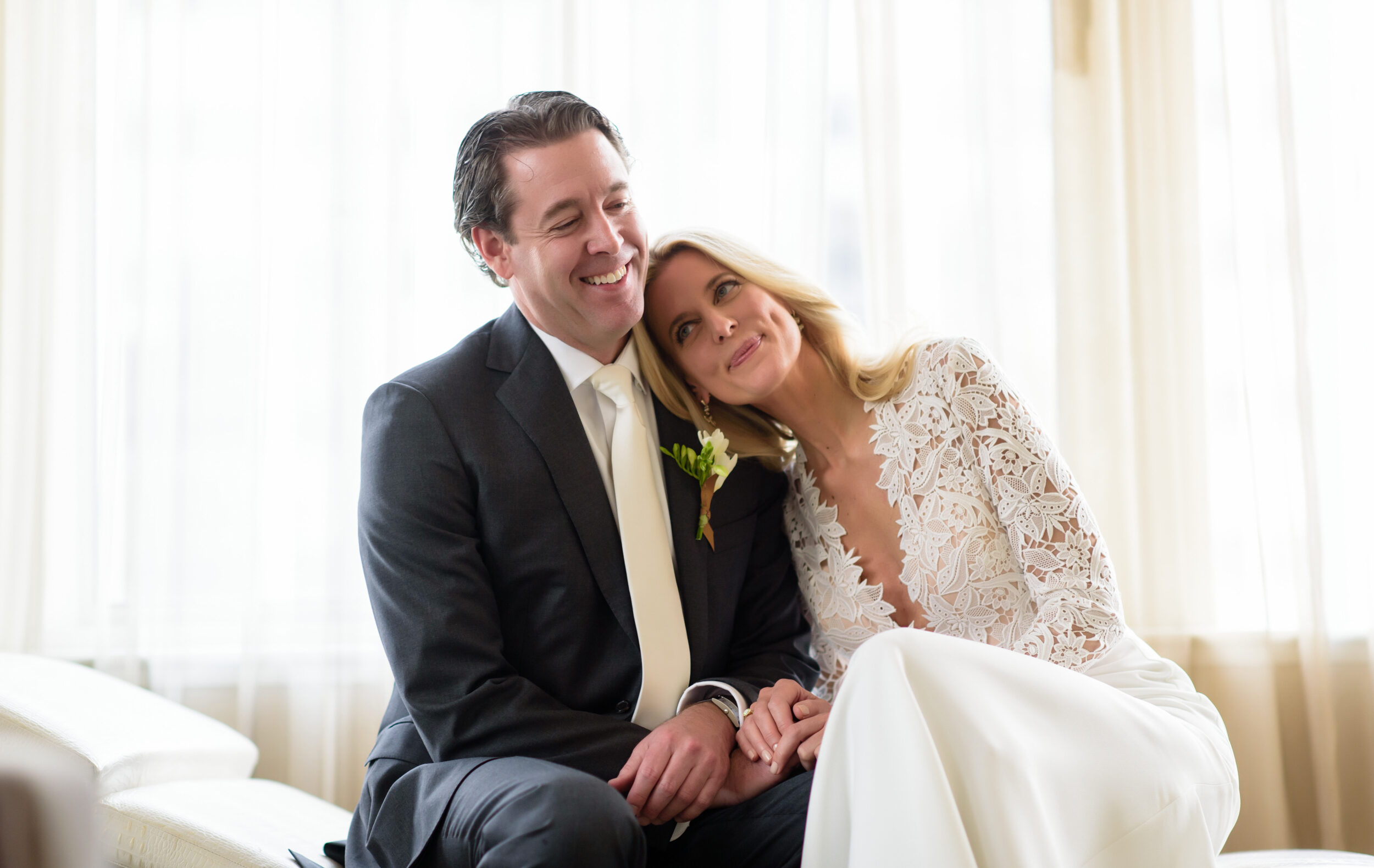 A bride and groom sitting on a couch in NYC.