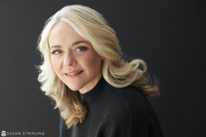 A woman with blonde hair posing for a headshot in NYC.