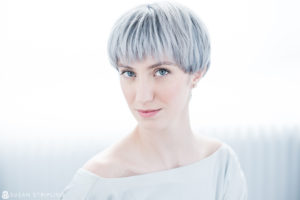 An elegant woman with gray hair is posing for a photo, suitable for headshots for actors in NYC.