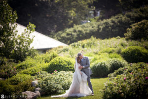 A Rhode Island bride and groom embracing in a garden at Ocean House for their wedding.