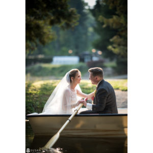 A couple in a boat on a lake, epitomizing a stunning wedding at Rock Creek Gardens.