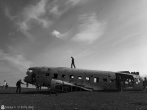 A man standing on top of an old airplane, taking Game of Thrones Location Photos.