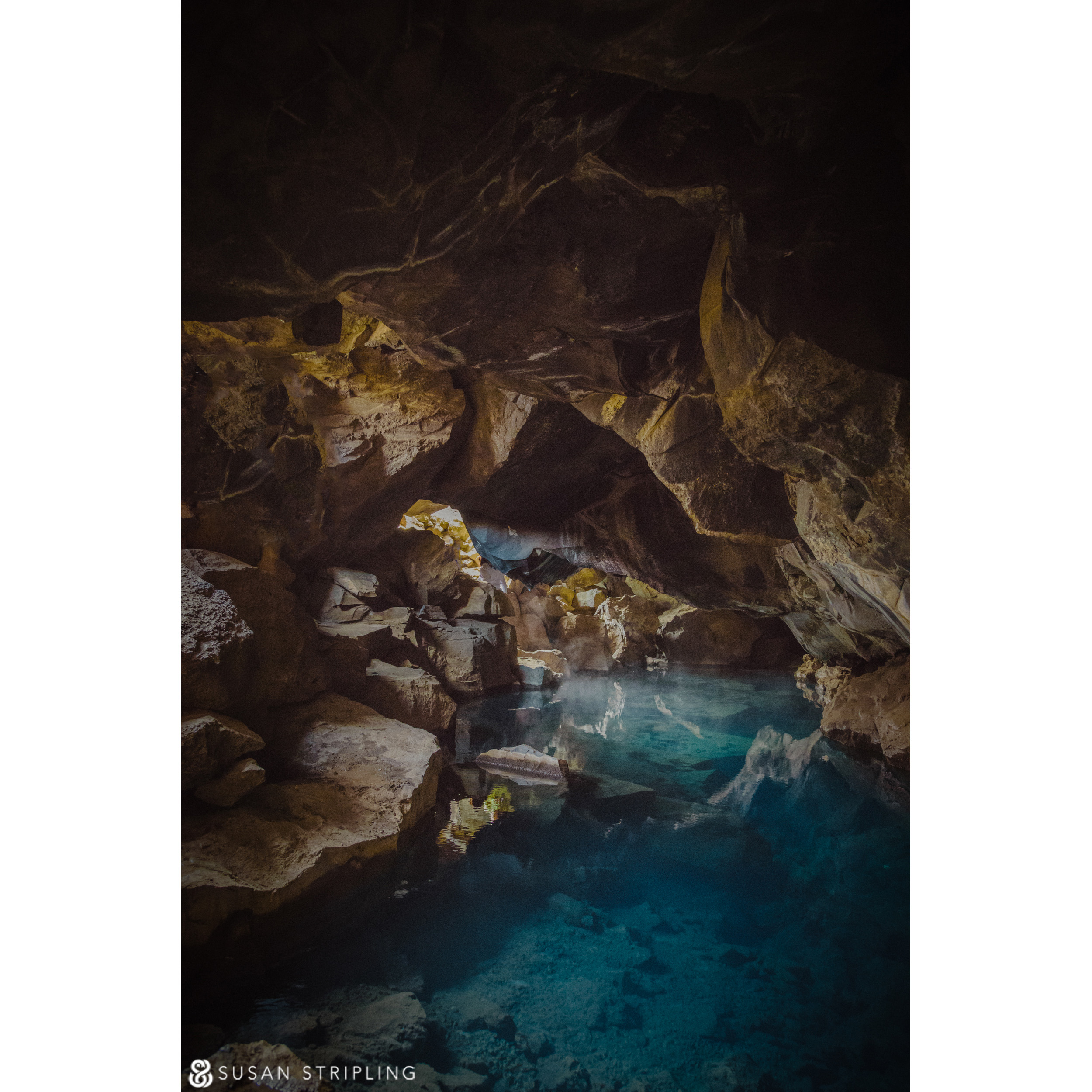 A blue pool in a cave with rocks around it, reminiscent of Game of Thrones Location Photos.