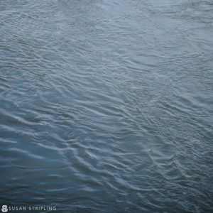 A man is riding a boat in a body of water, captured in Game of Thrones location photos.