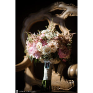 A bouquet of pink and white flowers sits on a chair at an Outdoor Wedding at Oheka Castle.