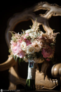 An outdoor wedding bouquet sits on a wooden chair at Oheka Castle.