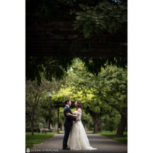 A bride and groom standing under a covered walkway at their Fall Wedding at the Brooklyn Botanic Garden.