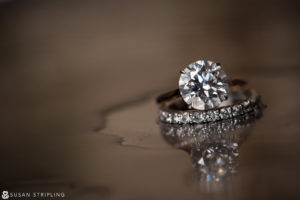 A diamond engagement ring sits on top of a table at a wedding at the Gramercy Park Hotel.