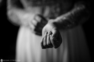 A black and white photo of a bride holding her wedding ring on her special day at the Hotel Du Village.