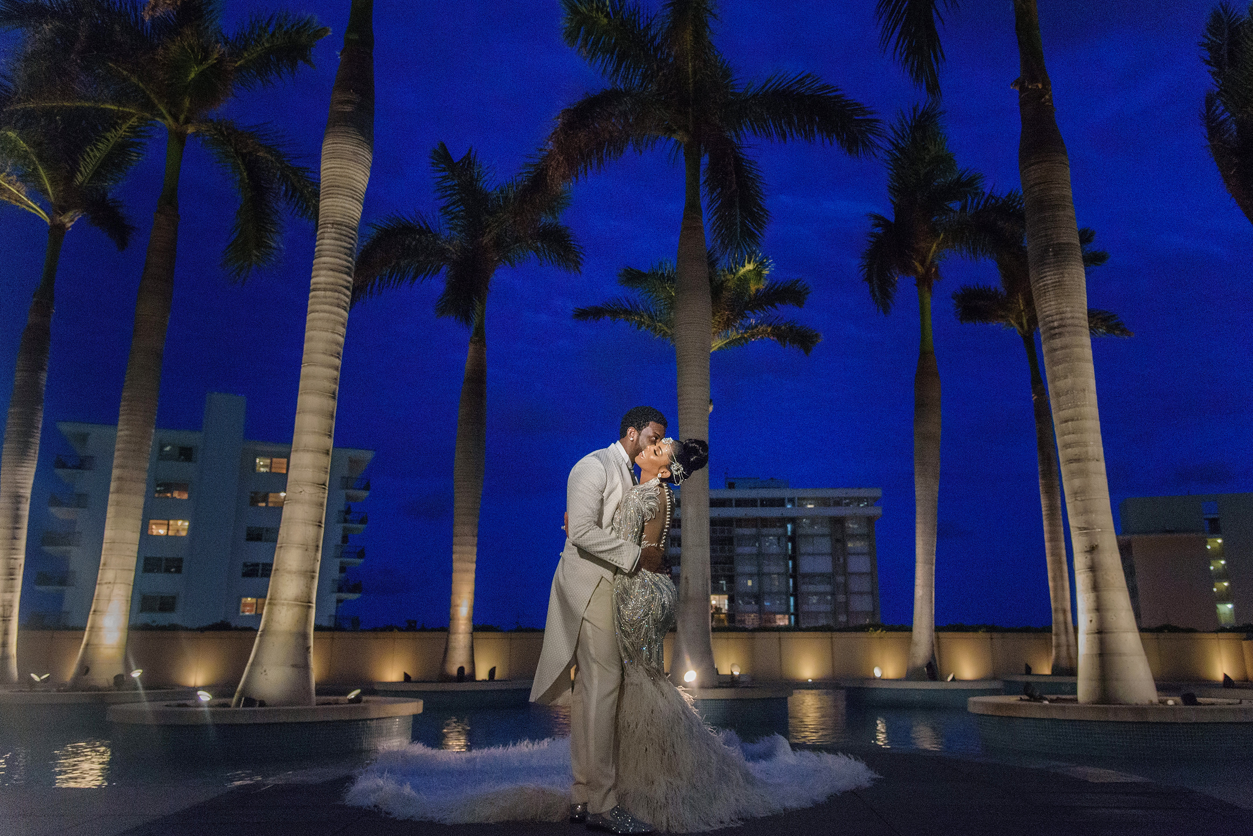 Gucci Mane and Keyshia Ka'oir kiss in front of palm trees at night in their wedding pictures.