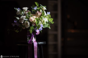 A purple and white bouquet sits on a stool at a wedding at Angel Orensanz.