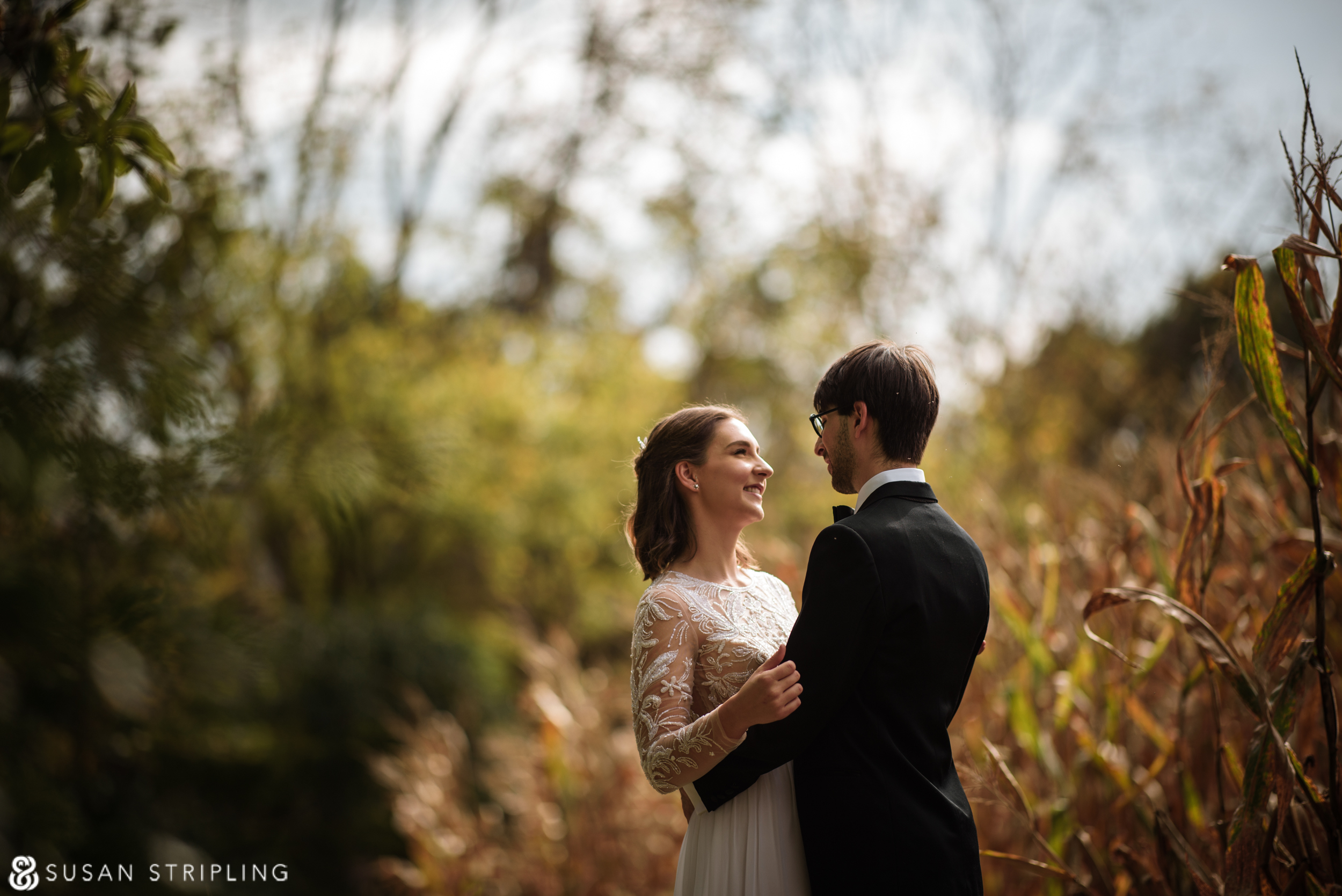 A bride and groom standing in a corn field, captured during their magical wedding at the Hotel Du Village.