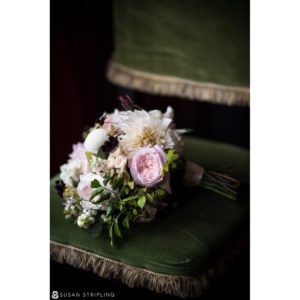 A bouquet of pink and white flowers sits on a green chair at a wedding at the Gramercy Park Hotel.