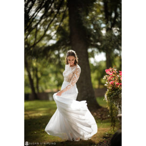 A bride in a white dress dancing in the grass at her Wedding at the Hotel Du Village.