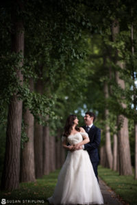 Keywords: Fall Wedding 

Description: A bride and groom standing in the middle of a wooded path, capturing the enchanting atmosphere of a fall wedding.