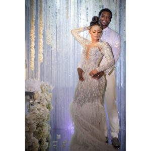 Gucci Mane and Keyshia Ka'oir posing for a photo in front of a white backdrop on their wedding day.