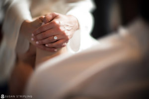 A woman's hand delicately cradling a wedding ring.
