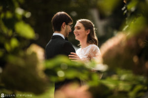 A bride and groom embracing in a garden during their Wedding at the Hotel Du Village.