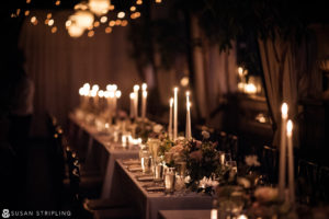 A stunning wedding reception at the Gramercy Park Hotel, featuring a beautifully decorated long table adorned with candles and flowers.