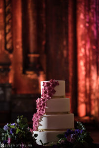A wedding cake sitting on a table at Angel Orensanz, in a dark room.