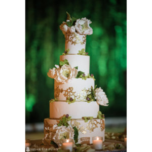 A New Jersey Indian wedding cake decorated with gold and green flowers.