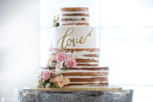 A summer wedding cake at the West Hills Country Club with the word "love" on it.