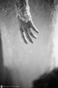 A black and white photo of a bride's hand adorned with a wedding ring, capturing the essence of a romantic New Year's Eve wedding.