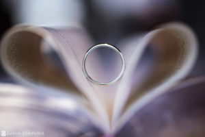 A wedding ring resting on top of an open book, capturing a dreamy moment in a Cescaphe Philadelphia wedding.