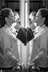 A woman is getting ready for her Cescaphe Philadelphia wedding in front of a mirror.