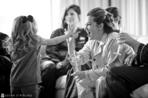 A woman is enthusiastically giving a little girl a high five during a Cescaphe Philadelphia wedding celebration.