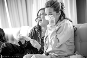 Two women crying while sitting on a couch at a Cescaphe Philadelphia wedding.