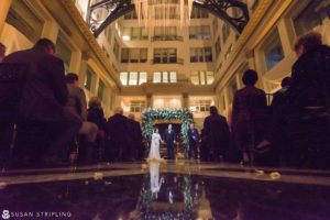 A cescaphe wedding ceremony in a Philadelphia atrium at night.
