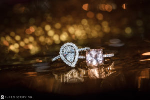 Two engagement rings displayed on a table during a wedding at Shadowbrook at Shrewsbury.
