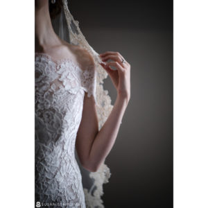 A destination wedding photographer captures stunning images of a bride in a lace wedding dress with a veil.