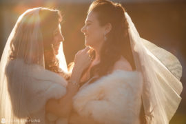 Two brides with fur shawls at their Wedding at Shadowbrook.