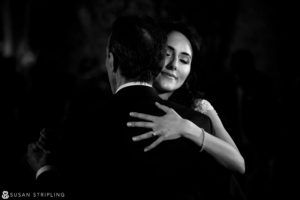 A bride and groom hugging during their first dance at a wedding at the Madison Hotel.