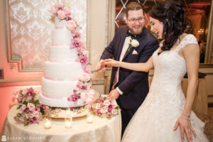 A bride and groom cutting into a wedding cake at the Madison Hotel.