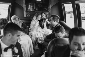 A black and white photo capturing a group of people in a limo, taken by a destination wedding photographer.