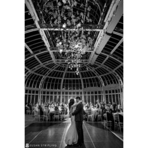 A bride and groom share their first dance at a winter wedding in a greenhouse at the Brooklyn Botanic Garden.