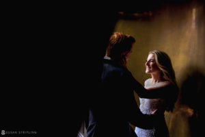 A bride and groom celebrating their rainy day wedding at Capitale, standing in a dark room.