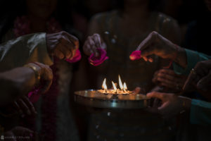 A group of Indian people lighting candles at a wedding ceremony in Atlanta.