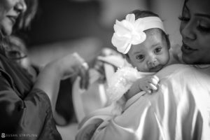 A black and white photo of a woman holding a baby at an Indian wedding at Tarrytown House Estate.