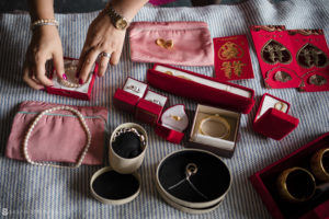 A woman is placing wedding jewelry on a table at 26 Bridge.