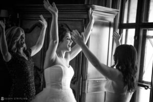 A bride and her bridesmaids are raising their hands in the air at a summer wedding at Cipriani 42nd Street.