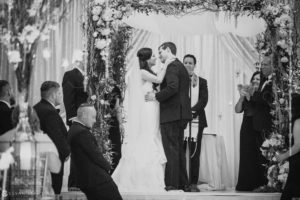 A bride and groom share a cherished kiss at their wedding ceremony at the Crystal Tea Room.