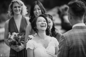 A bride laughs during her wedding ceremony at 26 Bridge.